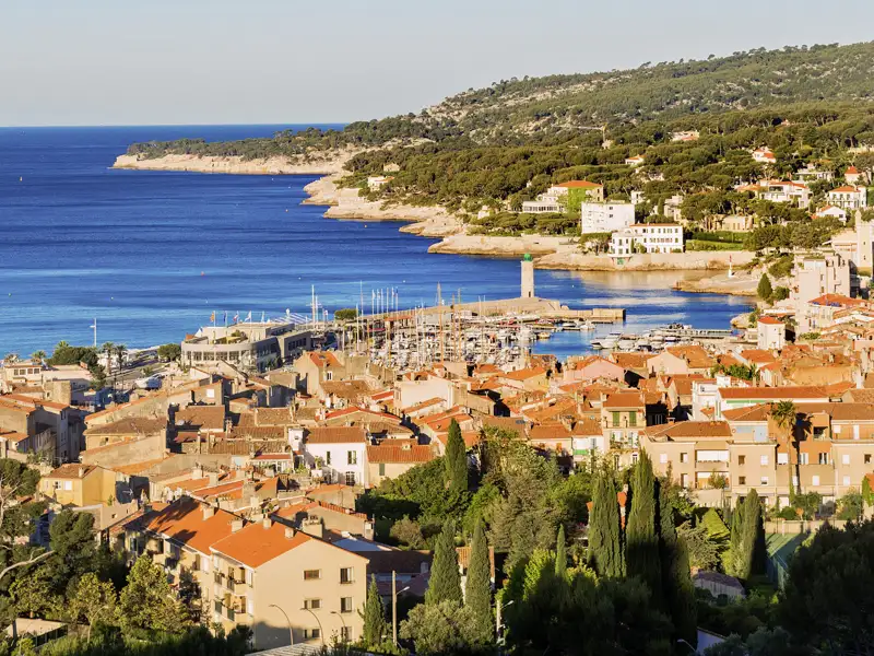 Panoramablick auf die Küstenstadt Cassis an der Côte d'Azur mit ihrem Hafen, den Häusern mit Ziegeldächern und dem Mittelmeer, ein Ausblick, den wir auf unserer Gruppenreise mit Studiosus genießen.