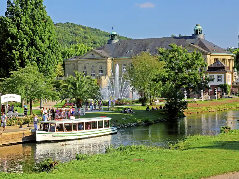 Reisende bei einer Bootsfahrt auf der Fränkischen Saale in Bad Kissingen mit Blick auf den prachtvollen Regentenbau im Kurpark, ein Highlight auf unserer Rundreise mit Studiosus.