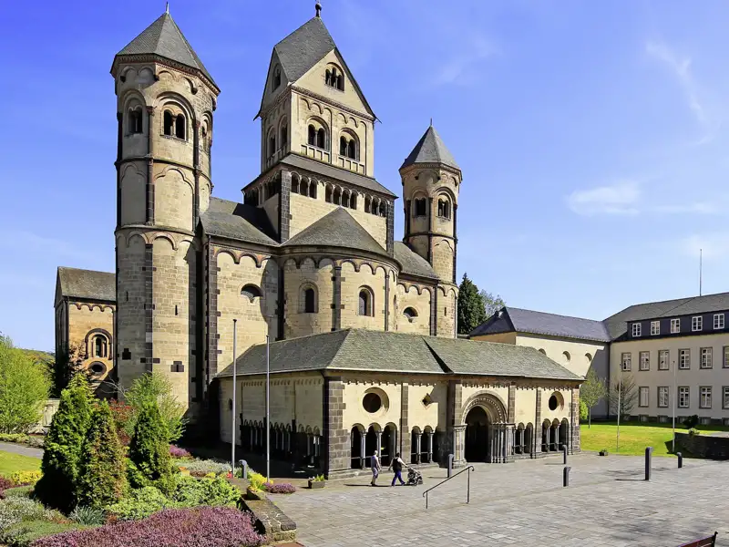 Die imposante romanische Basilika der Abtei Maria Laach mit ihren sechs Türmen an einem sonnigen Tag mit dem gepflegten Vorplatz, ein toller Anblick auf der Studienreise .