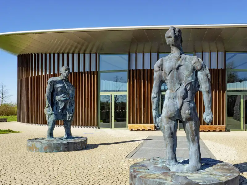 Kunst im Park: Zwei große Bronzeskulpturen vor einem modernen Ausstellungsgebäude im Museum Hombroich am Niederrhein, ein Stopp auf unserer Eventreise mit Studiosus.