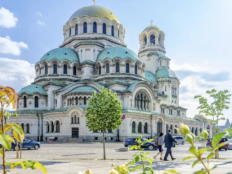Ein Paar spaziert bei Sonnenschein vor der imposanten Alexander-Newski-Kathedrale mit goldenen Kuppeln in Sofia, Bulgarien, ein Highlight auf unserer Gruppenreise mit Studiosus