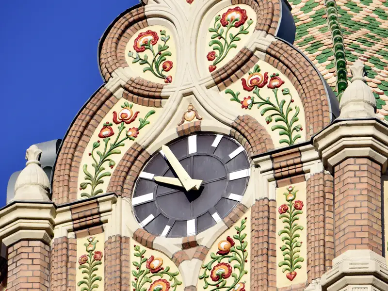 Nahaufnahme der Uhr am Rathaus von Kiskunfélegyháza mit bunten, floralen Majolika-Ornamenten des ungarischen Jugendstils, ein toller Anblick auf unserer Studiosus Rundreise.