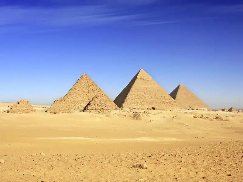 Blick auf die weltberühmten Pyramiden von Gizeh, ein Höhepunkt der Studiosus Studienreise durch Ägyptens Norden bei strahlend blauem Himmel.