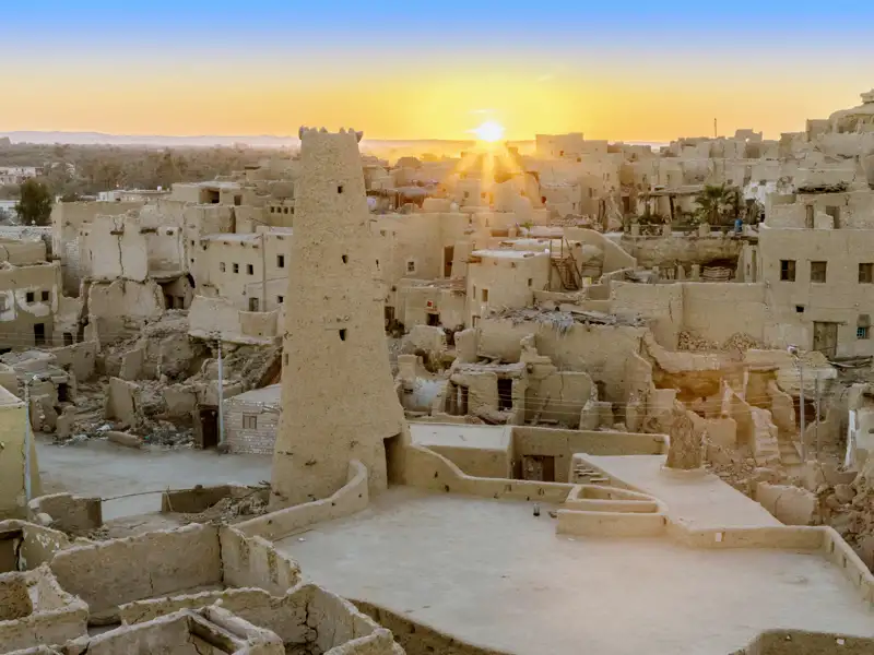 Sonnenuntergang über den alten Lehmbauten der Festung Shali in der Oase Siwa während einer Studiosus Studienreise durch Ägypten.