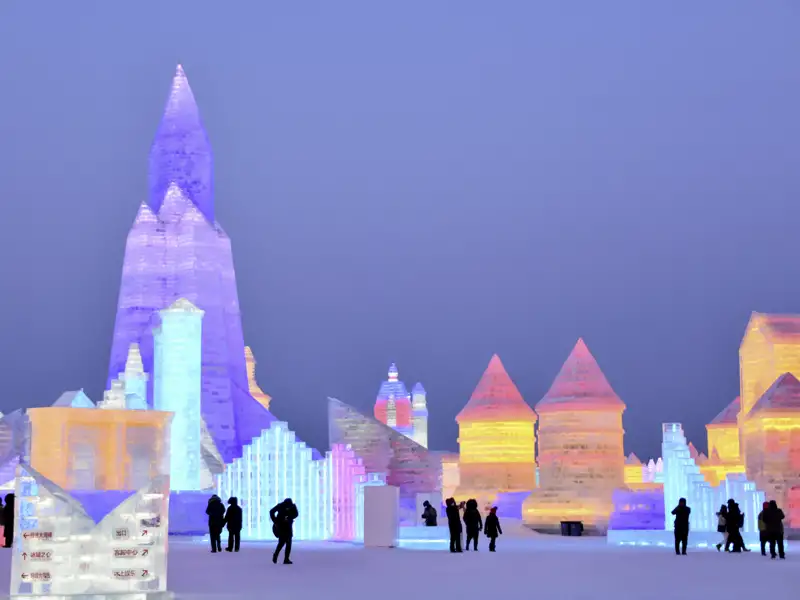 Auf unserer Studiosus Eventreise können wir die riesigen, in bunten Farben illuminierten Eispaläste auf dem Eisfestival in Harbin, China bestaunen.
