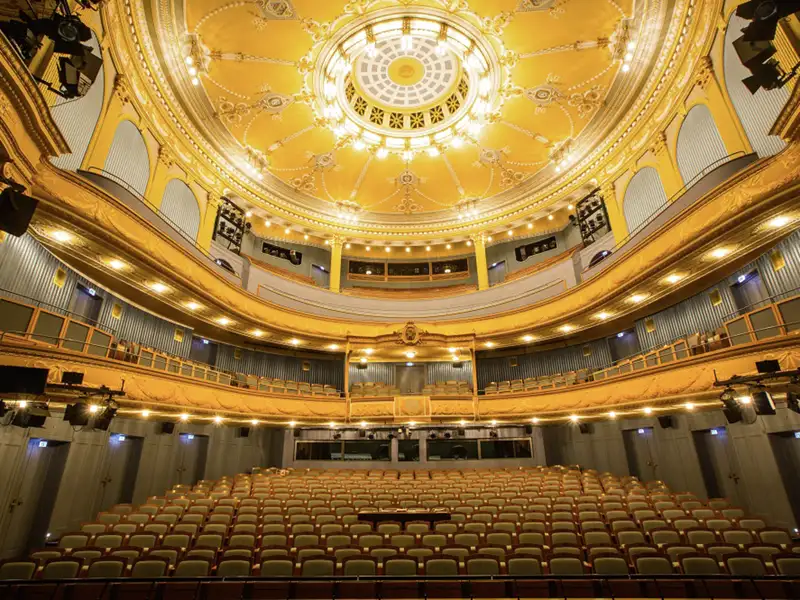 Der leere Zuschauerraum des Meininger Staatstheaters mit prunkvollen goldenen Logen und einer verzierten Deckenkuppel, ein Highlight unserer Eventreise mit Studiosus.