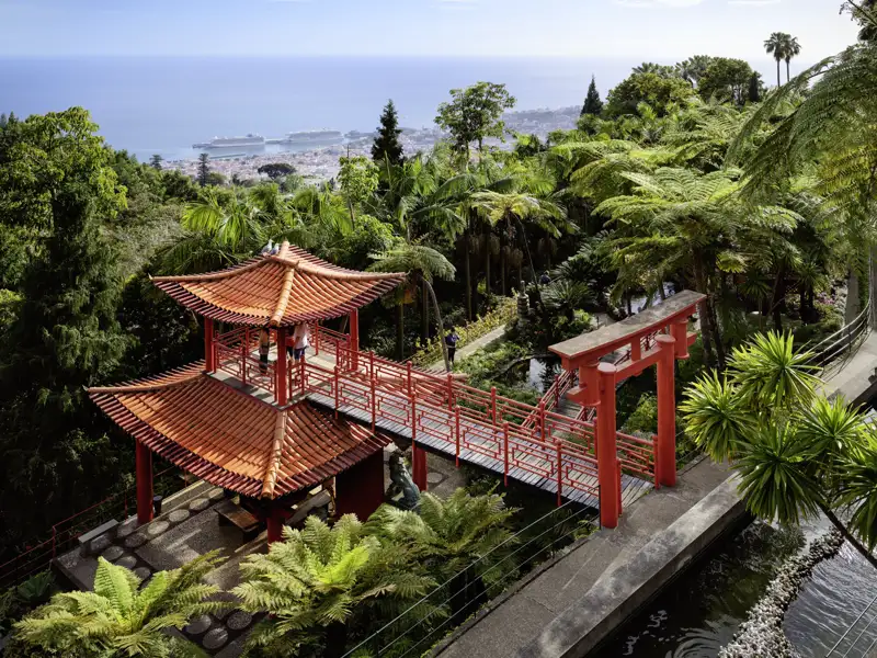 Rote Pagode und Brücke im tropischen Palastgarten von Monte mit Panoramablick über Funchal und das Meer.