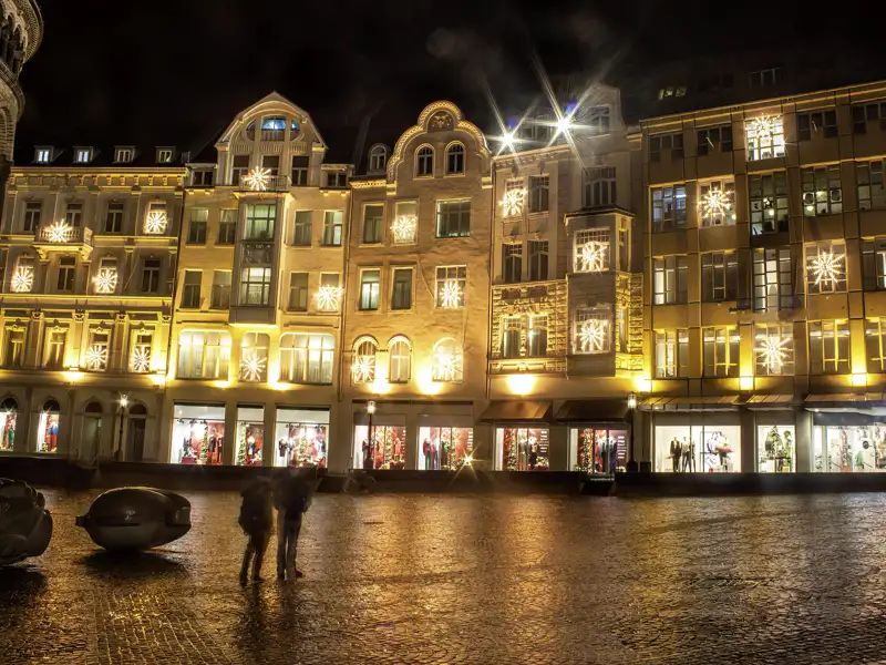 Nasser Marktplatz in Bonn, dessen historische Gebäudefronten zu Silvester festlich mit Schneeflocken-Lichtern beleuchtet sind.