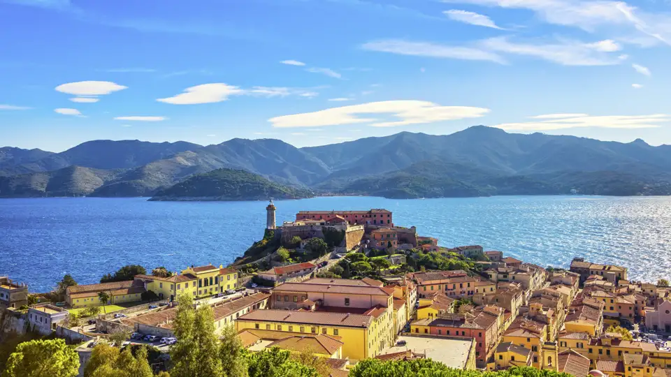 Malerischer Blick über die Altstadt von Portoferraio auf das Forte Stella mit Leuchtturm vor der Bergkulisse Elbas, ein Highlight auf unserer Rundreise mit Studiosus.