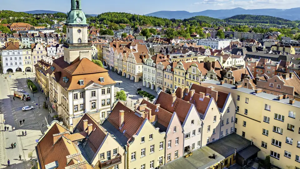 Panoramablick auf den Marktplatz von Jelenia Góra mit dem Rathausturm, bunten Giebelhäusern und dem Riesengebirge im Hintergrund, ein toller Ausblick auf unserer Gruppenreise mit Studiosus.