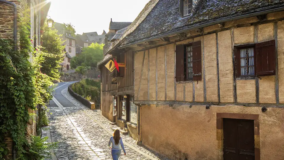 Im Rahmen unserer Gruppenreise spazieren wir durch enge Gassen mit Fachwerkhäusern im mittelalterlichen Dorf Conques.