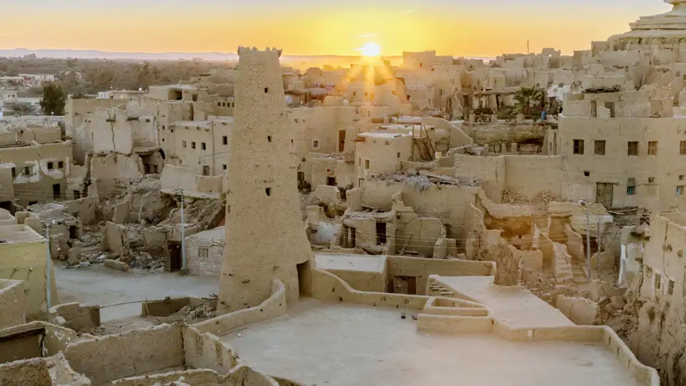 Sonnenuntergang über den alten Lehmbauten der Festung Shali in der Oase Siwa während einer Studiosus Studienreise durch Ägypten.
