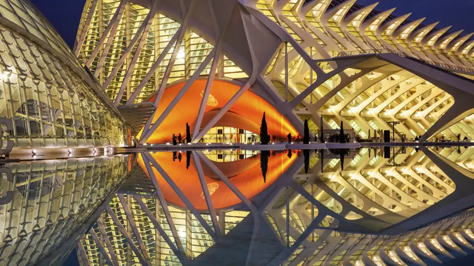 Das futuristische Opernhaus in der Stadt der Künste und Wissenschaften in Valencia, bei Nacht beleuchtet und sich im Wasser spiegelnd. Ein Highlight Ihrer Gruppenreise.