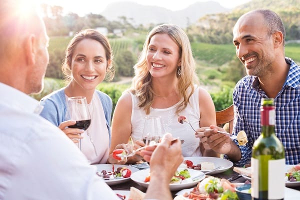 Vier Menschen genießen ein geschmackvolles Essen im Freien.
