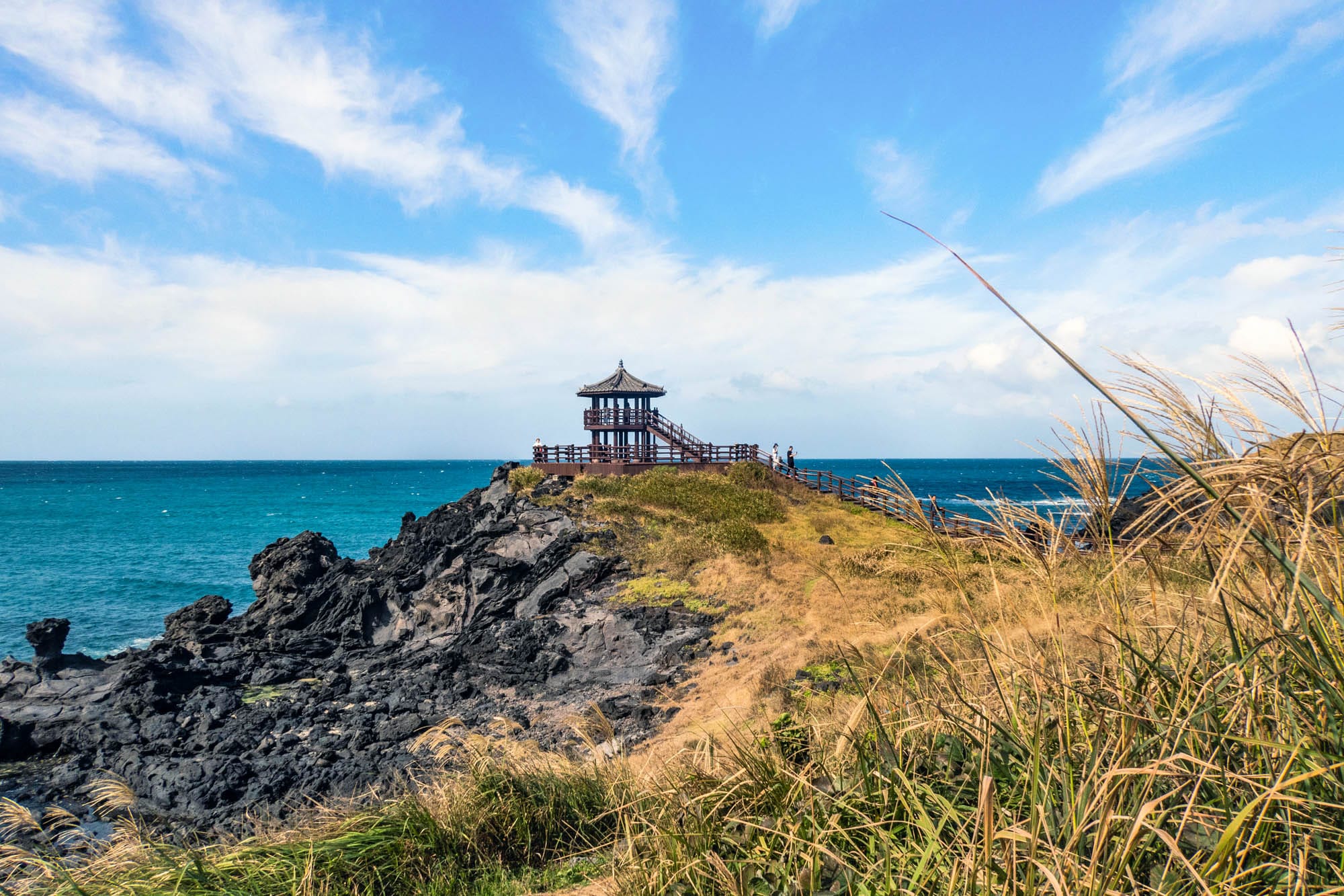 Auf Route 20 des Jeju Olle Trails kommen Wanderer am Sehwa Beach Pavilion vorbei. Der Strand selbst zeichnet sich durch seinen kobaltblauen Farbverlauf, weißen Sand und schwarze Basaltfelsen aus.