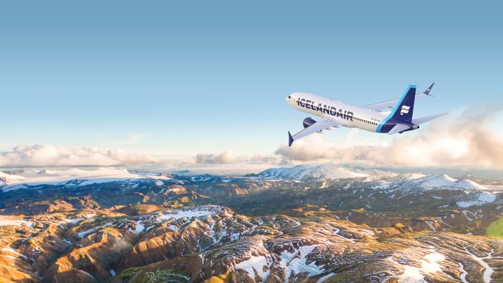 Ein Flugzeug von Icelandair fliegt über eine Berglandschaft.