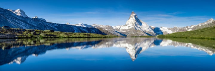 Ein Panoramablick auf dem Berg Matterhorn mit einer Wiederspiegelung in einem Bergsee.