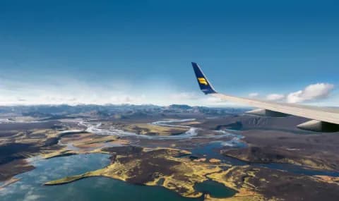 Maschine der Icelandair im Flug über der rauhen Landschaft islands.